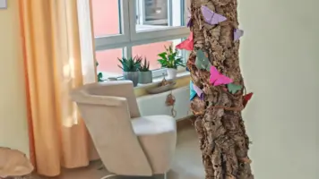 Sitzgruppe im Eingang. Deko mit Schmetterlinge aus Papier zur Erinnerung an verstorbene Hospizgäste