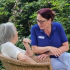 Pflegekraft im Gespräch mit einem Gast aus dem Hospiz